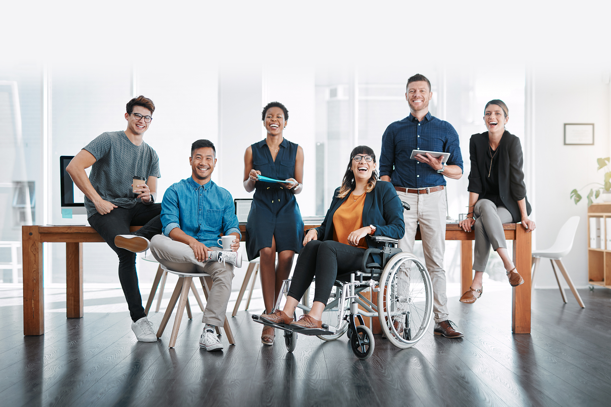 Grupo diverso de trabajadores, con y sin discapacidad, en una oficina.